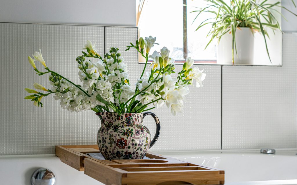 Fresh flowers add a touch of elegance to a beautifully lit bathroom. Source: Unsplash
